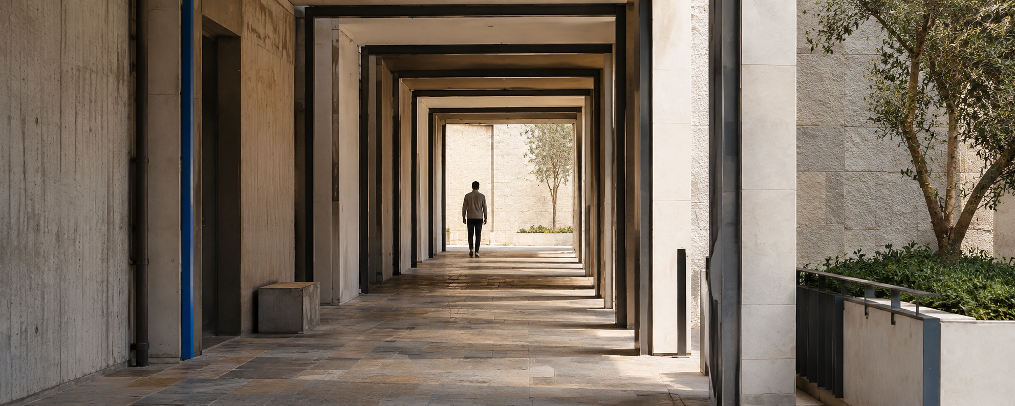 A person walking through a sequence of sunlit architectural frames